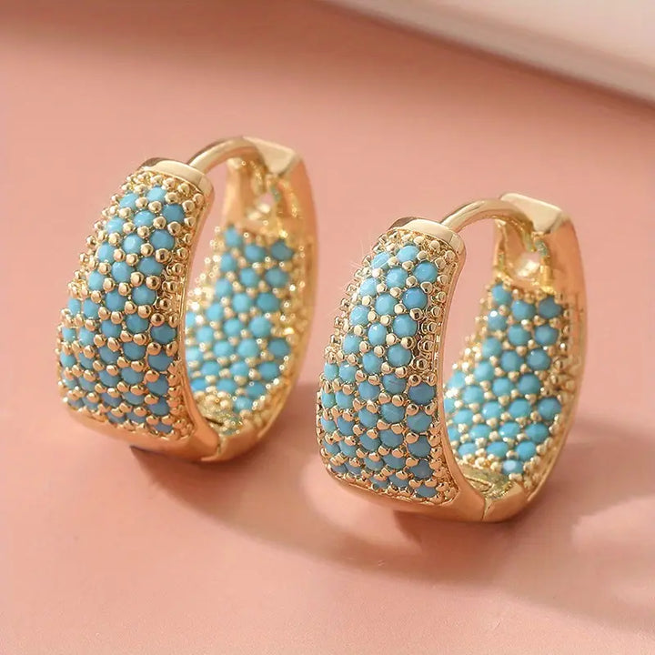 Elegante goldfarbene Creolen mit türkisfarbenen Perlen