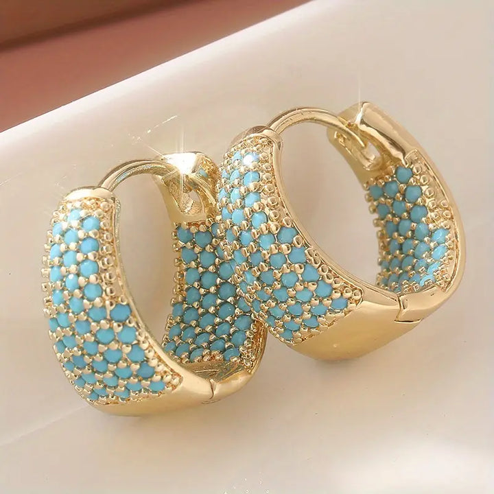 Elegante goldfarbene Creolen mit türkisfarbenen Perlen
