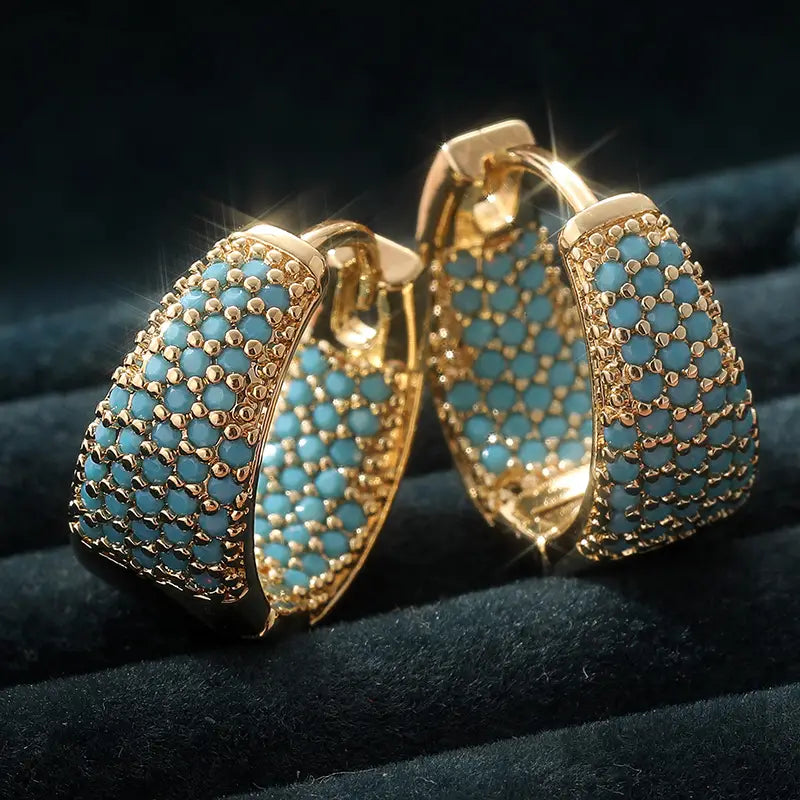 Elegante goldfarbene Creolen mit türkisfarbenen Perlen